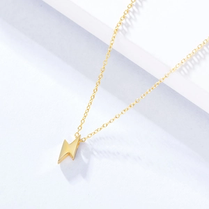 Close-up of minimalist gold lightning bolt pendant on a delicate S925 silver chain