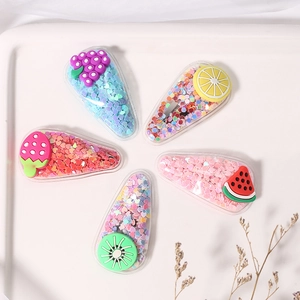 Detail of colorful fruit-themed hair clips with sparkling sequins and transparent finish