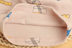Detailed close-up of pink knit cotton fabric with cartoon patterns and ribbed stitching