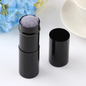 Dettaglio pennello trucco retrattile con tubo nero lucido e setole in fibra viola morbide