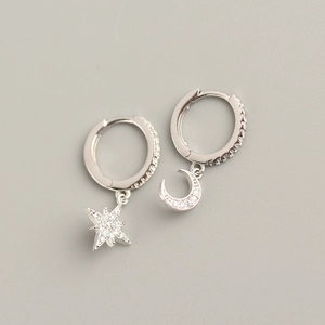 Detailed view of S925 sterling silver asymmetric star and moon earrings with small crystals