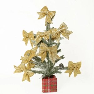 Detail showing shiny gold glitter bows decorated on a small Christmas tree with red plaid base