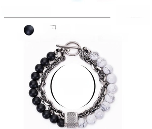 Detail view of men's matte black stone and white turquoise bracelet with steel T-bar clasp