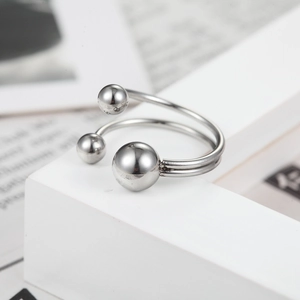 Minimalist double-line silver stainless steel ring with metal beads on geometric stand