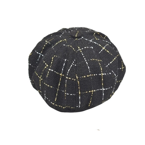 Détail du béret noir à carreaux en dentelle montrant la texture en tweed doré chic