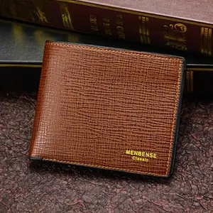 Close-up of a dark brown men's wallet with cross-pattern texture on vintage books