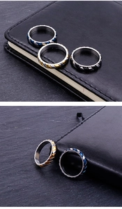 Close-up of stainless steel rings with twisted rope grooves in blue, gold and black