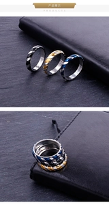 Detailed view of three stainless steel rings with diagonal grooved texture in black, gold, and blue