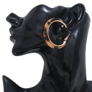 Elegant C-shaped acetate earrings in tortoiseshell with gold metal on a mannequin