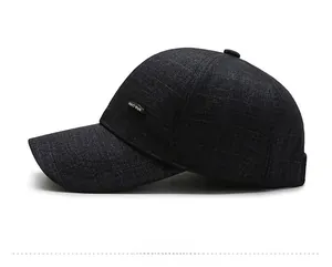 Detail of dark grey plaid baseball cap showing fabric texture and metal logo plaque