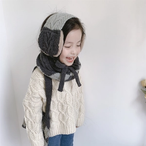 Detailed close-up of knitted grey two-tone winter scarf and earmuffs set for kids