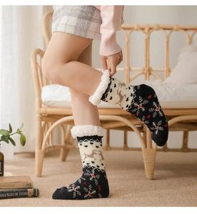 Close-up of thick fleece-lined winter home socks with reindeer and snowflake patterns