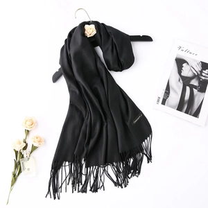 Detail of black cashmere scarf texture with fringe and elegant lifestyle props