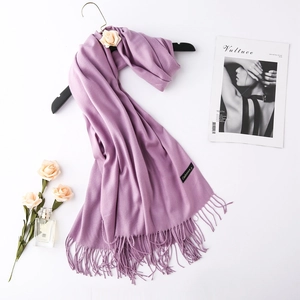 Close-up of purple cashmere scarf with fringe details and a stylish magazine layout