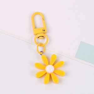 Cute yellow daisy keychain for AirPods with metal hook on white and blue background