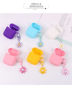 Flat lay of silicone earphone cases in various colors with daisy charms and carabiners