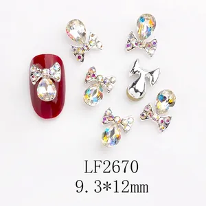 Détail de bijoux d'ongles en forme de nœud avec strass aux reflets irisés AB