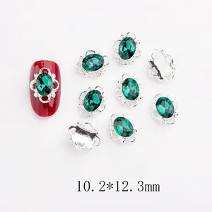 Détail de bijoux d'ongles en cristal vert émeraude sur monture argentée, taille 10,2x12,3mm