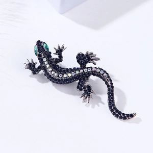 Macro detail of lizard brooch with black rhinestones and sparkling green gemstone eyes