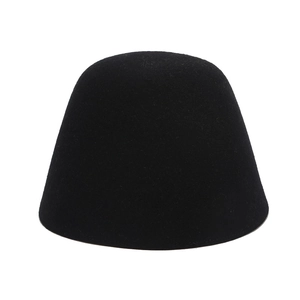 Dettaglio della spessa trama in feltro e design minimalista di un cappello in lana nera
