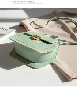 Detailed view of mint green hexagonal PU shoulder bag with yellow stitching and gold lock