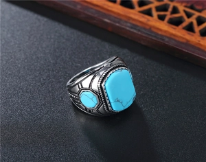 Close-up of vintage turquoise ring for men with silver metal and ethnic wooden background