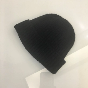 Detailed view of black knitted beanie showing classic ribbed texture and folded cuff edge