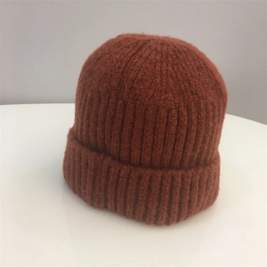 Detailed close-up showing the caramel ribbed knit texture and cuffed edge of the beanie