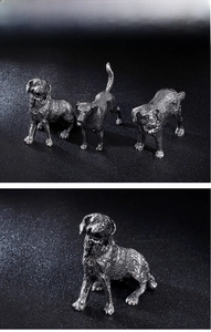 Macro detail of fine steel dog figurine showing intricate hair texture and vintage finish