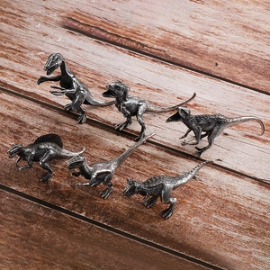 Set of 6 vintage silver stainless steel dinosaur metal models on wood background