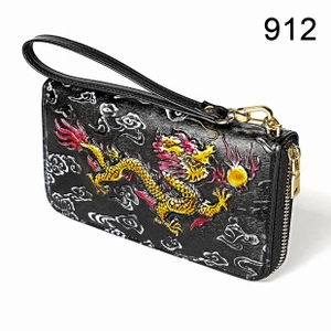 Close-up of black leather wallet with colorful Chinese dragon relief and gold zipper