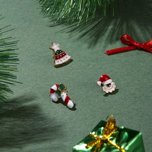 Detailed view of Christmas themed enamel earring set with tree and Santa motifs