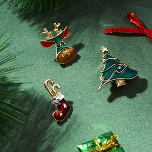 Detailed view of Christmas tree, reindeer, and sock enamel brooches with rhinestones