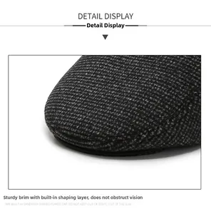 Detailed close-up of a sturdy grey tweed peak on a warm winter flat cap for elderly men