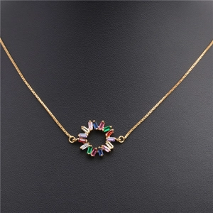 Detailed close-up of a gold necklace with a circular pendant set with rainbow cubic zirconia