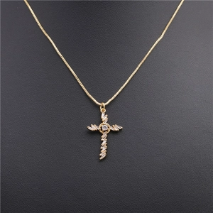 Macro detail of gold cross pendant featuring sparkling cubic zirconia on a box chain
