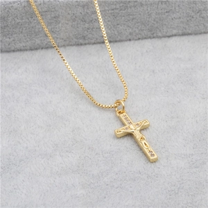 Macro view of gold box chain and crucifix pendant with inlaid micro-zirconia stones