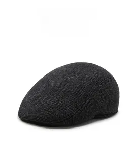 Detailed close-up of dark grey winter flat cap with thick textured knitted wool fabric