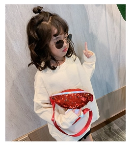 Dettaglio di bambina con marsupio rosso di paillettes con tracolla in nylon regolabile