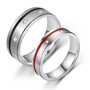 Close-up of brushed titanium rings for couples featuring red and black inlay with zircon