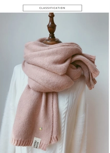Détail d'une écharpe en tricot rose avec broderie ananas et étiquette en tissu
