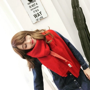 Gros plan d'une écharpe en maille rouge douce portée par un mannequin dans un cadre lumineux