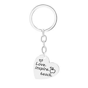 Detail of silver heart keychain engraved with Love Inspire Teach and an apple icon