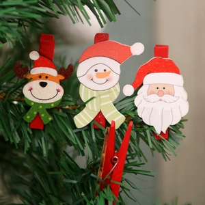 Set di mollette natalizie in legno con Babbo Natale e renna su un ramo verde