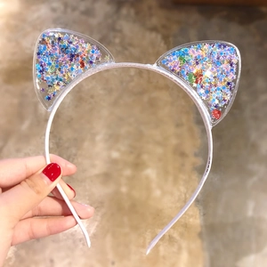 Detail of cute cat ear headband with colorful star sequins inside transparent ears