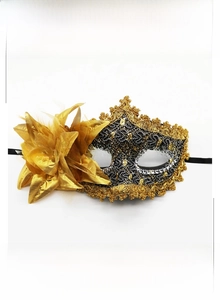 Detail of Venice lace mask with golden feathers and satin rose for masquerade parties