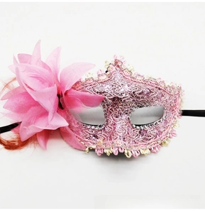 Detail of pink lace masquerade mask featuring side floral rose and feather accents