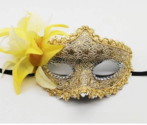 Detailed close-up of Venetian lace mask with golden sequins and large yellow silk flower