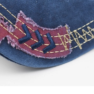 Macro detail of 3D embroidered patch with distressed edges on navy cotton baseball cap