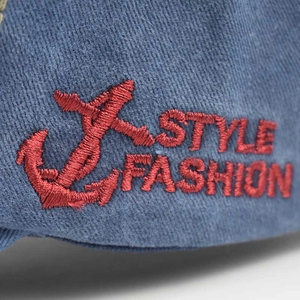 Close-up of red anchor embroidery and Style Fashion text on blue cotton baseball cap